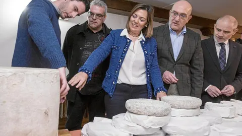La consejera Milagros Marcos examina los quesos ante la atenta mirada de Carnero y Caramanzana.