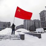 Un hombre sostiene una bandera del partido comunista en el 92º aniversario de la muerte de Lenin