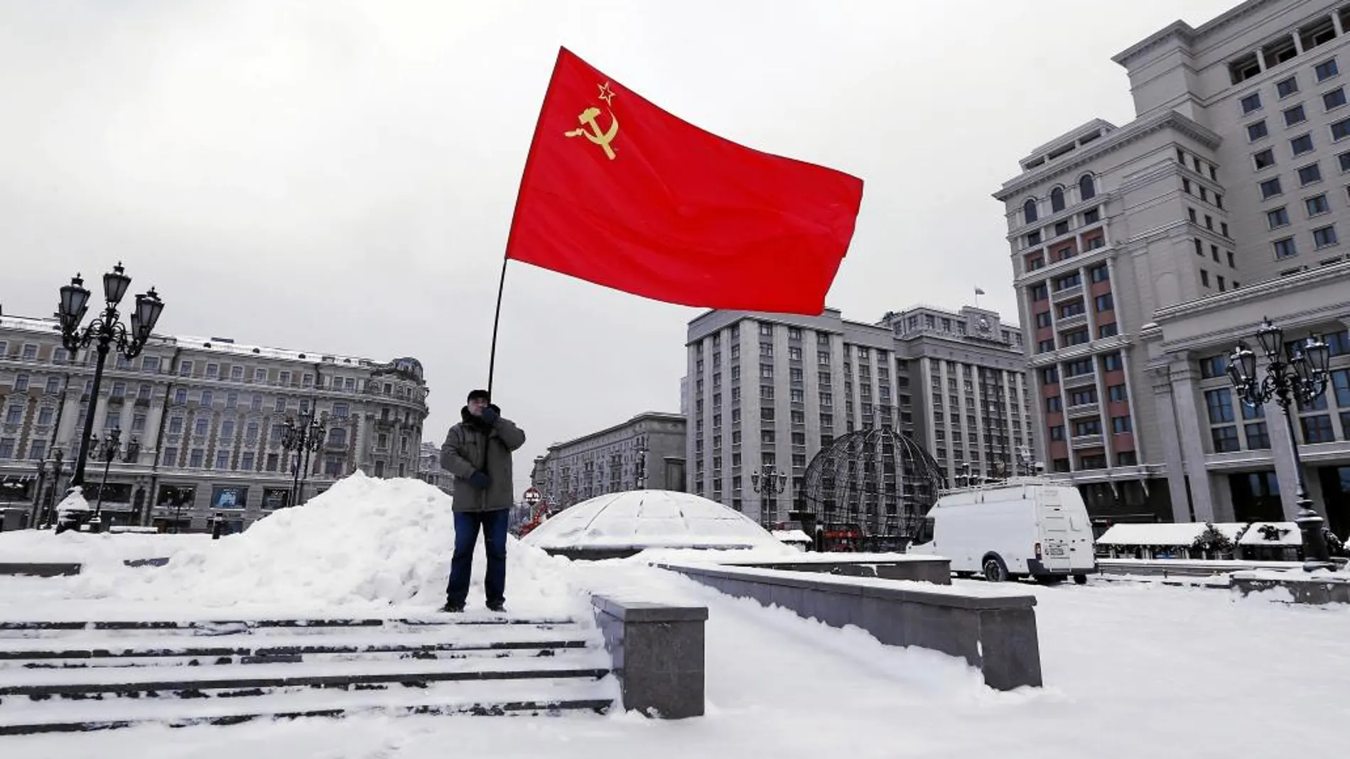 Un hombre sostiene una bandera del partido comunista en el 92º aniversario de la muerte de Lenin