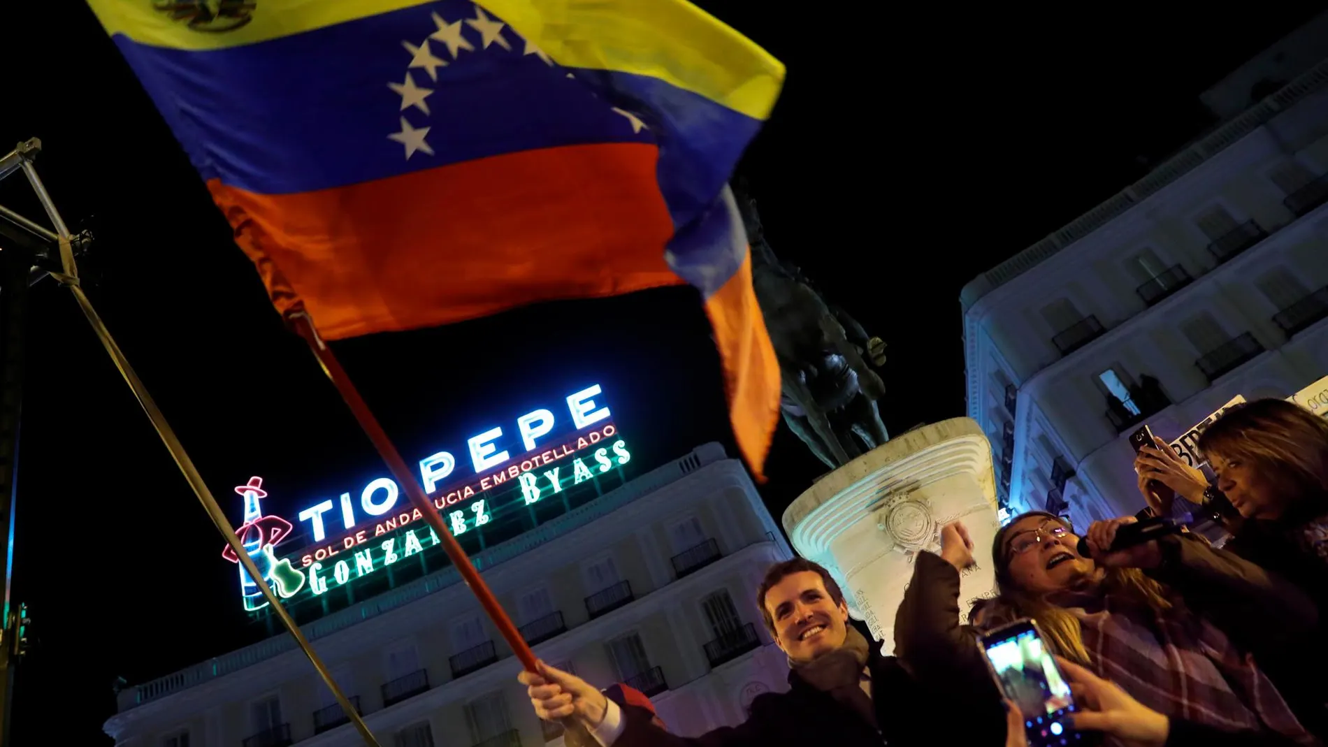Casado (PP) porta una bandera de Venezuela en la concentración que tuvo lugar en Madrid / Efe