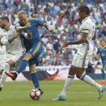 El delantero sueco del Celta de Vigo, John Guidetti, intenta golpear el balón ante los defensores del Real Madrid, Sergio Ramos y Varane