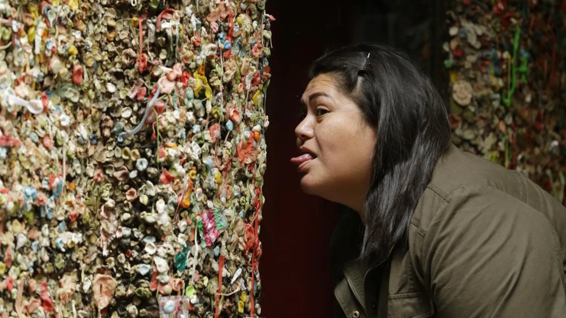 Una joven bromea con los chicles pegados en la pared