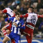 El jugador del Deportivo de La Coruña Oriol Riera pelea un balón ccon varios jugadores del Granada