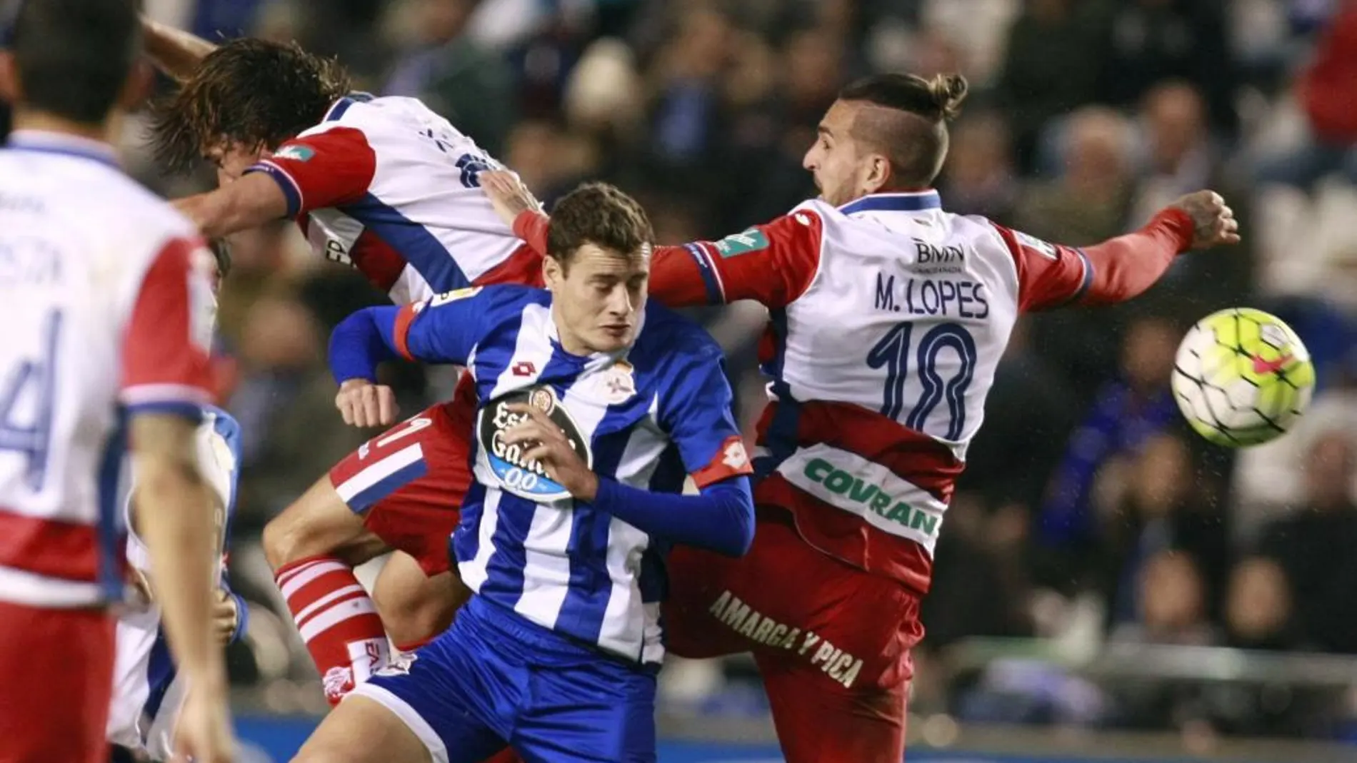 El jugador del Deportivo de La Coruña Oriol Riera pelea un balón ccon varios jugadores del Granada