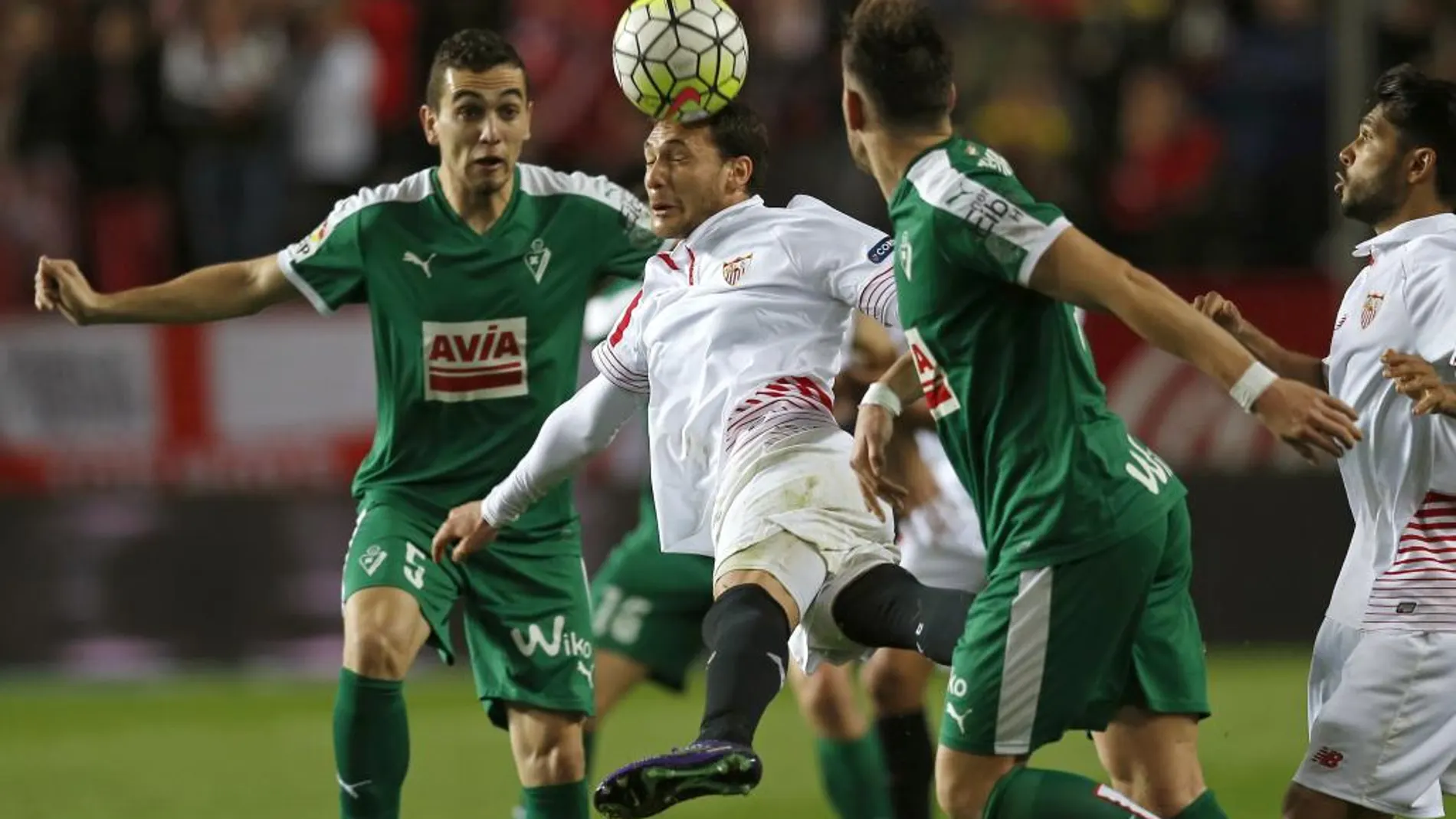 El centrocampista uruguayo del Sevilla Sebastián Carlos Cristóforo (c) cabecea el balón ante el los jugadores del Eibar Gonzalo Escalante (i) y Sergi Enrich