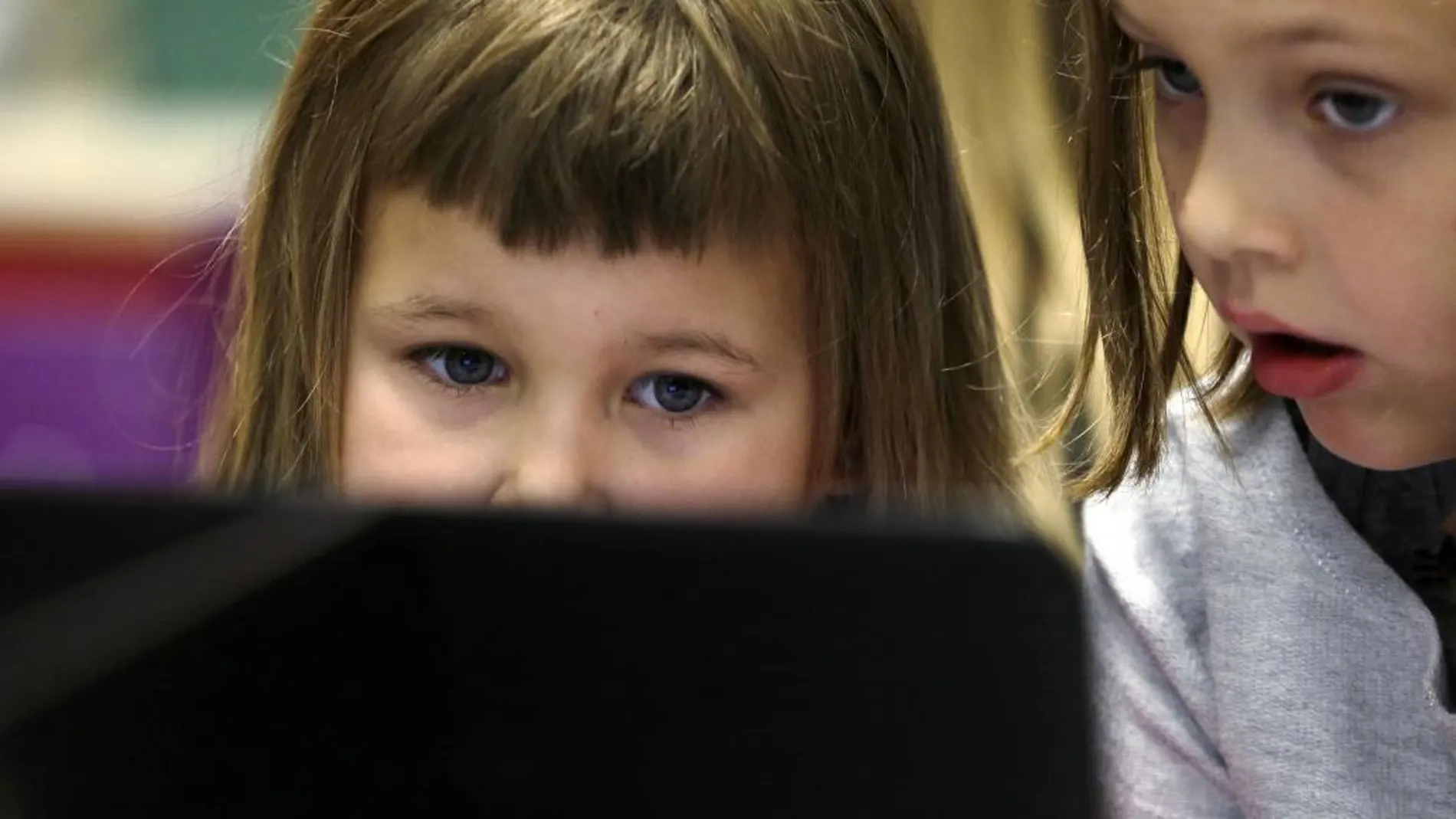 Dos niños frente a un ordenador en una guardería