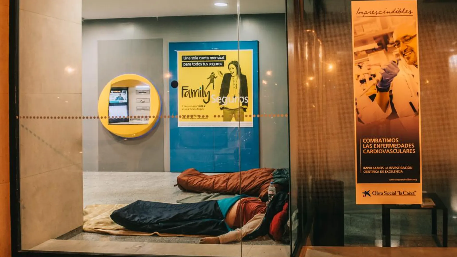Dos personas sin hogar duermen en un cajero de la ciudad de Valencia