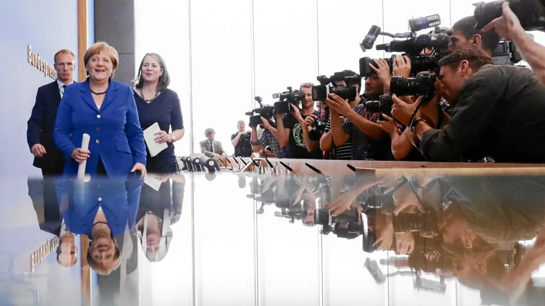 Angela Merkel, enfocada por decenas de cámaras, tras su rueda de prensa de ayer en Berlín
