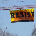 Siete activistas de Greenpeace extienden una bandera con la palabra "Resist"(lit. Resistir) desde una grúa cerca de la Casa Blanca