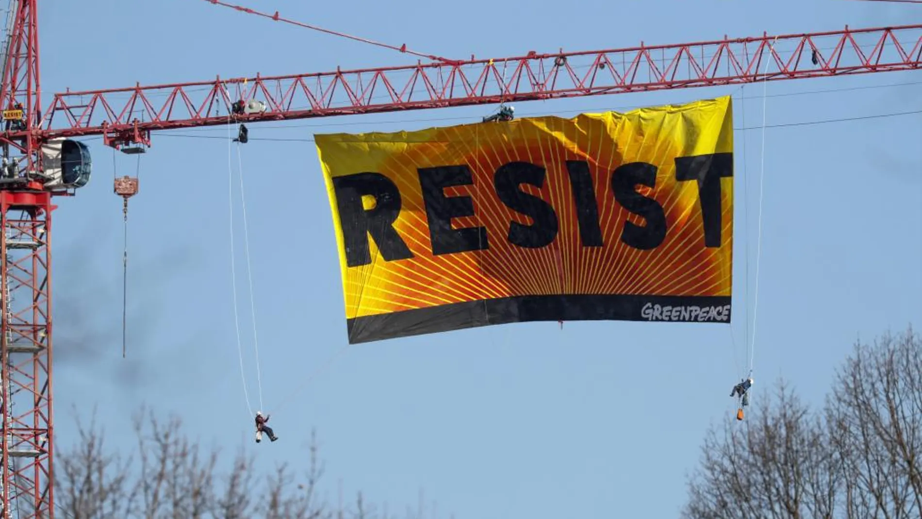 Siete activistas de Greenpeace extienden una bandera con la palabra "Resist"(lit. Resistir) desde una grúa cerca de la Casa Blanca