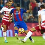 Suárez (c) con el balón ante los jugadores del Granada, David Rodríguez Lombán (d) y Roberto Román Triguero