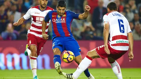 Suárez (c) con el balón ante los jugadores del Granada, David Rodríguez Lombán (d) y Roberto Román Triguero