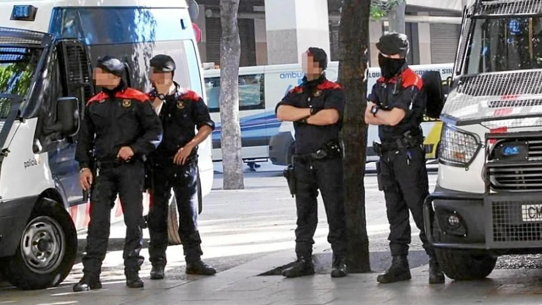 Agentes de los Mossos d’Esquadra, ayer cerca del banco atracado, en el lugar de los hechos