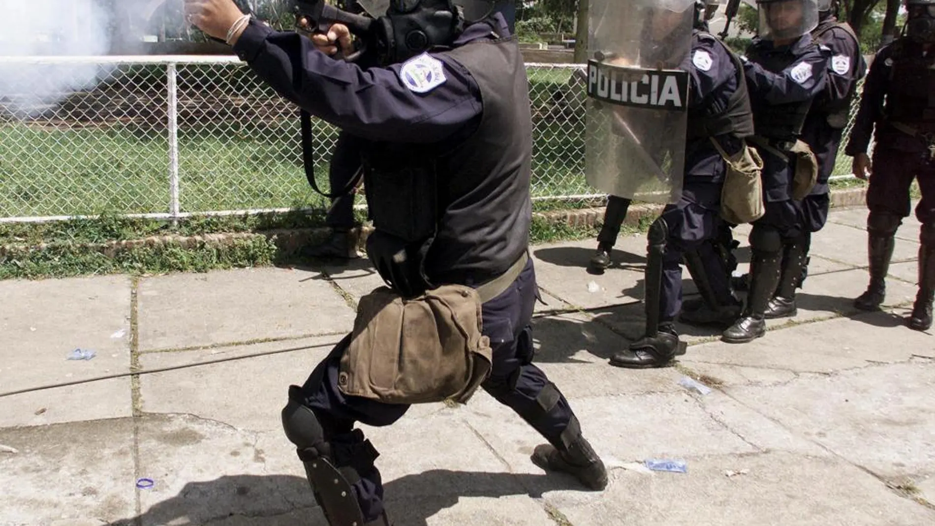 Un agente dispara una pelota de goma contra unos manifestantes