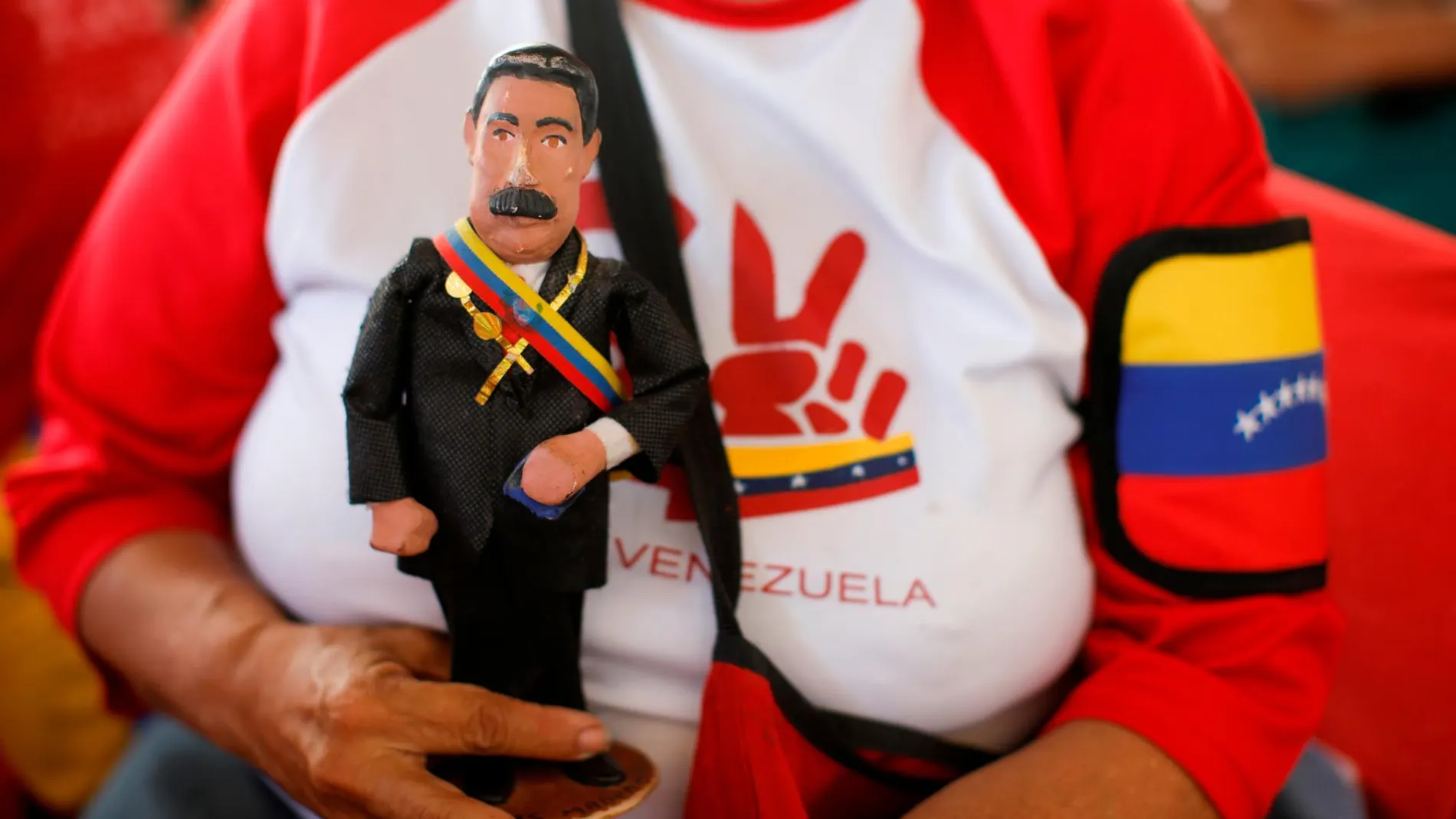 Una simpatizante del dictador sujeta una figurita de Nicolás Maduro