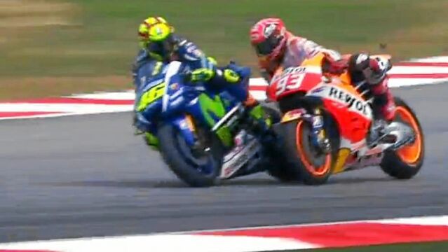 Marc, al ver que se va a salir de la pista, mete la moto hacia dentro y contacta con la del italiano, que saca la pierna y suelta una patada.