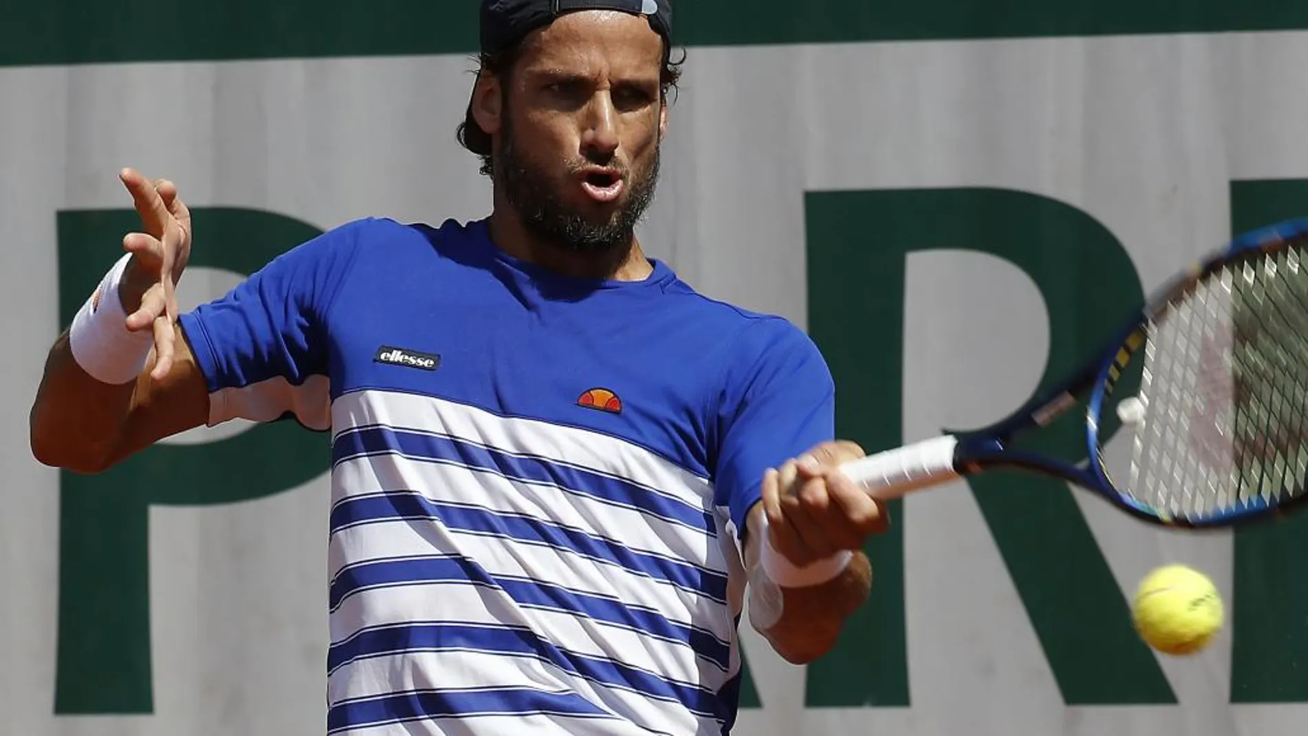 El tenista español Feliciano López golpea la bola contra su compatriota David Ferrer durante su partido de la segunda ronda de Roland Garros