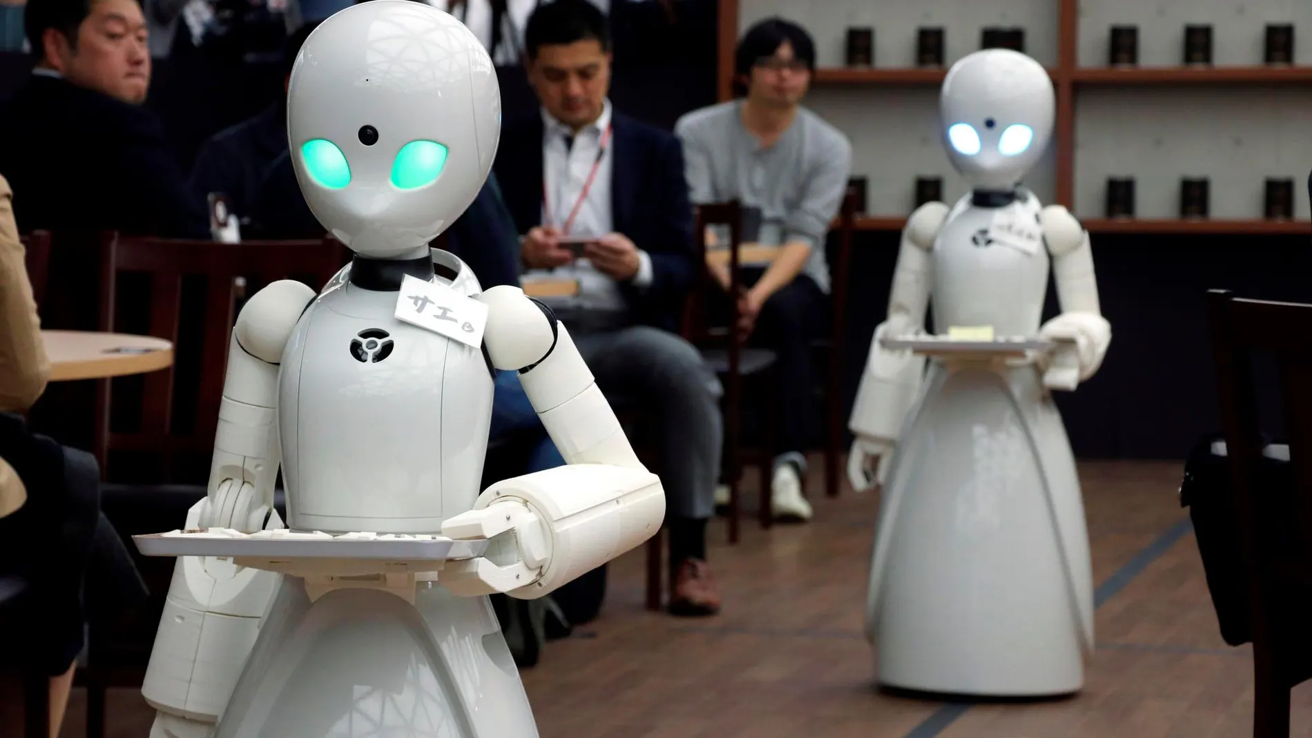 Un café de Tokio ha lanzado un proyecto pionero para utilizar robots como camareros, manejados a distancia por una persona discapacitada. En la imagen se ven las máquinas atendiendo a los clientes / Efe