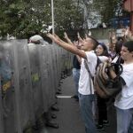 Estudiantes universitarios gritan contra la “dictadura” en Caracas frente a la Guardia Nacional Bolivariana.