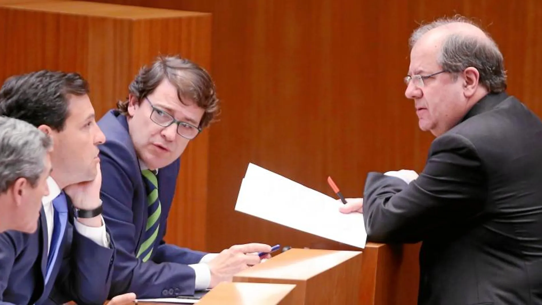 El jefe del Ejecutivo, Juan Vicente Herrera, conversa durante el pleno con el presidente del PP, Alfonso Fernández Mañueco, y el portavoz del Grupo, Raúl de la Hoz