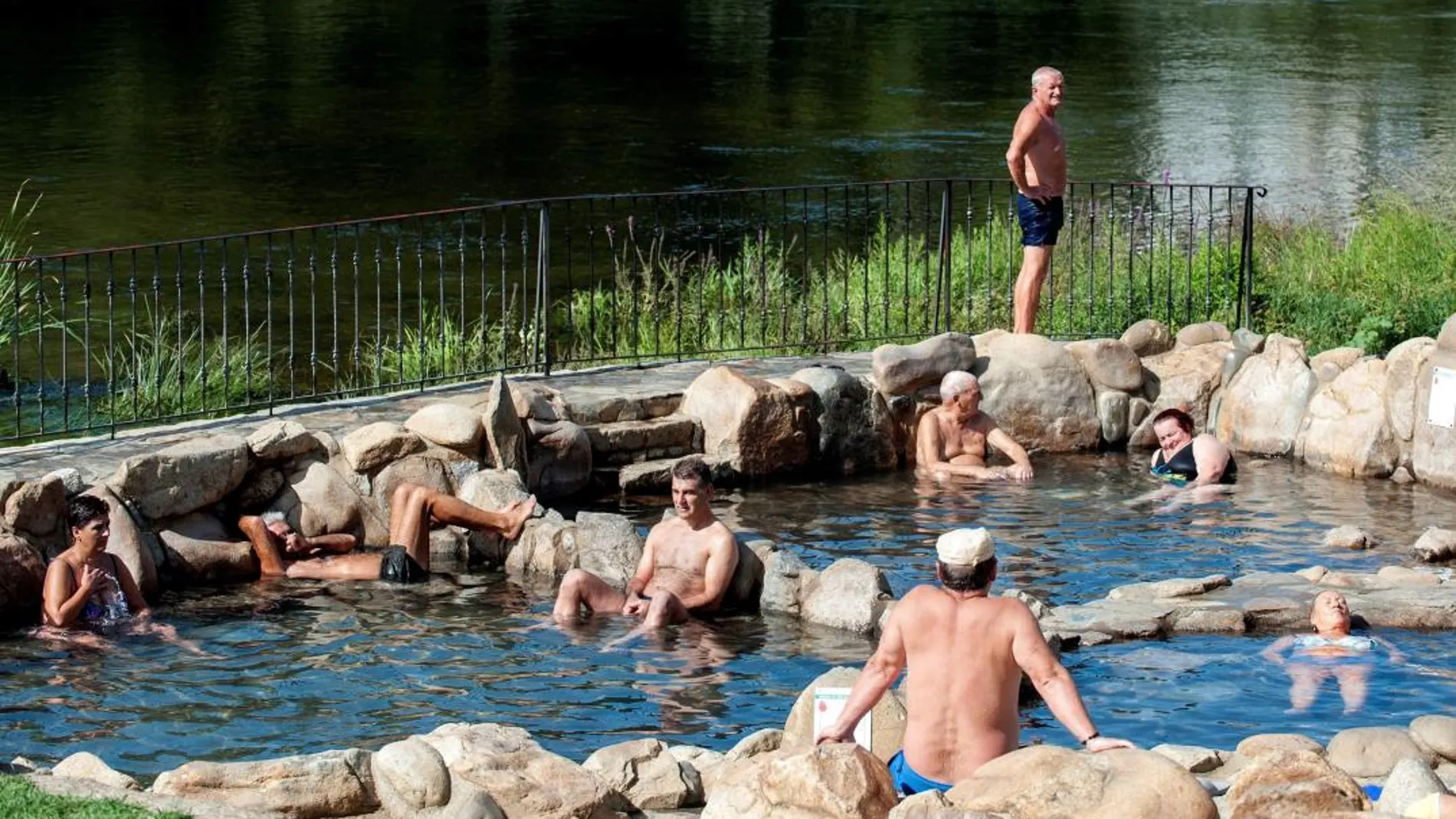 Varias personas disfrutan de las altas temperaturas registradas en Orense, en la zona fluvial del río Miño y las termas de A Chavasqueira/Foto: Efe