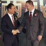 El ejecutivo del grupo chino Wanda, Wang Jianlin (i), estrecha la mano del ejecutivo de la compañía estadounidense de cine Legendary, Thomas Tull