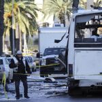 Policías forenses tunecinos inspeccionan los restos de un autobús tras el atentado contra varios guardias presidenciales que se encontraban a bordo del vehículo, en Túnez
