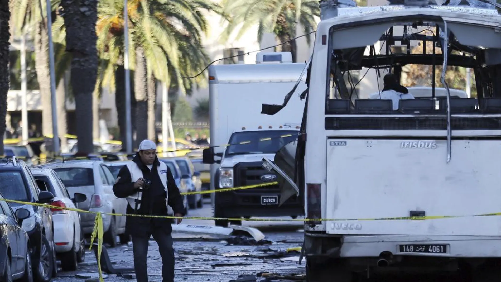 Policías forenses tunecinos inspeccionan los restos de un autobús tras el atentado contra varios guardias presidenciales que se encontraban a bordo del vehículo, en Túnez