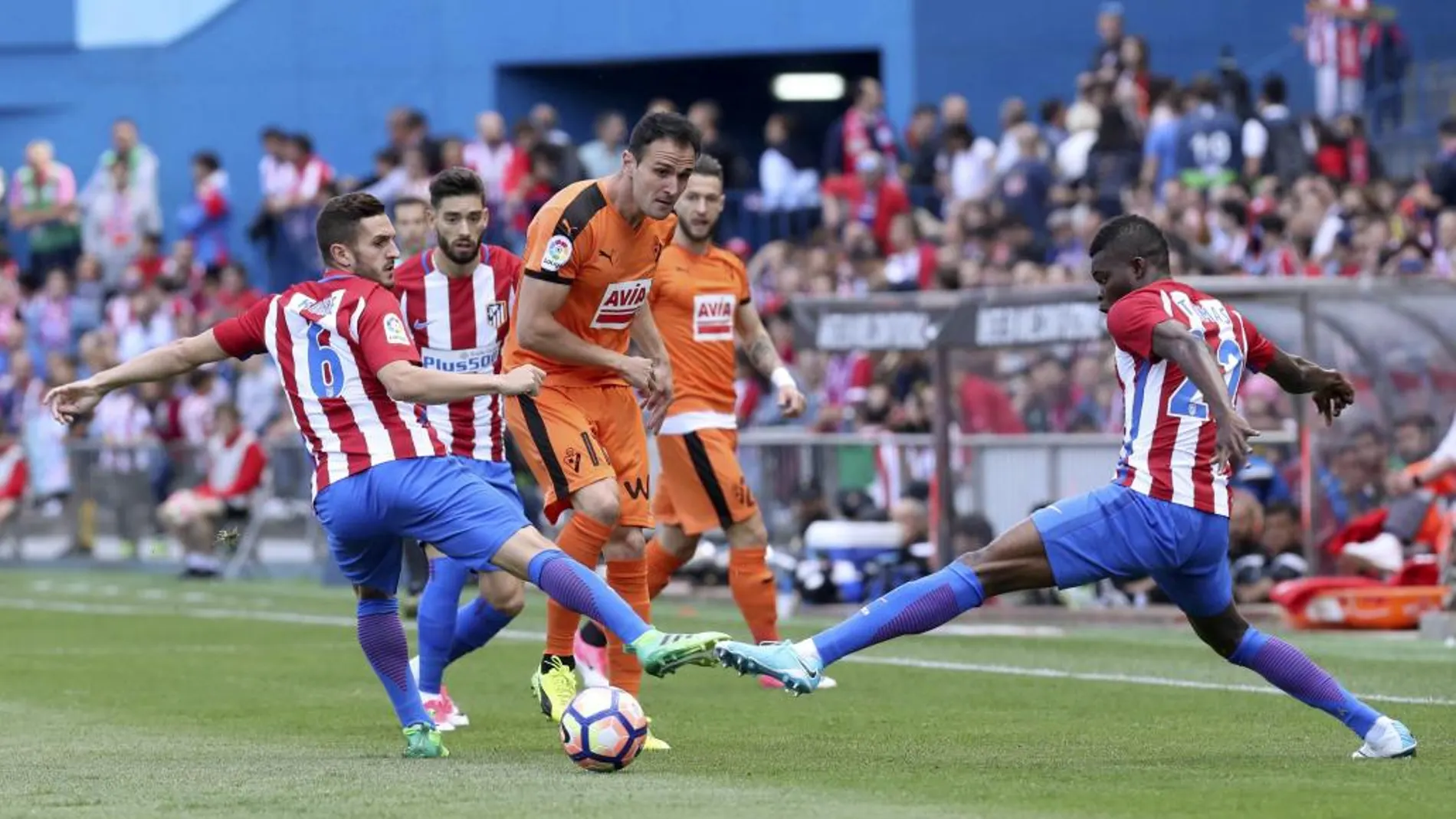Los jugadores del Atlético de Madrid Koke Resurrección (i) y Thomas (d) disputa un balón con el delantero del Eibar Kike García