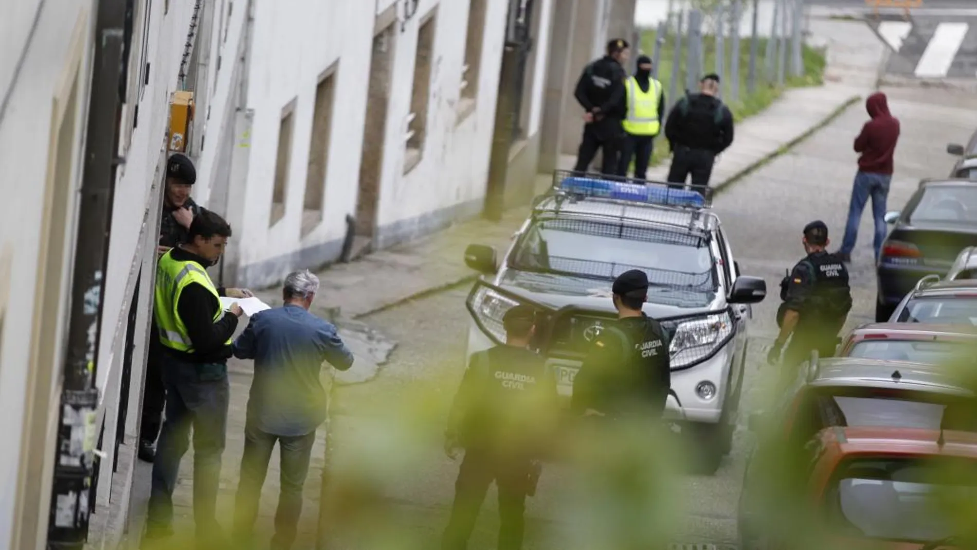 Agentes de la Guardia Civil durante un registro realizado hoy en Santiago de Compostela, en el marco de una operación llevada a cabo contra la Resistencia Galega