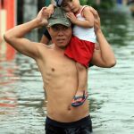 Un niño rescatado por su padre tras unas inundaciones en Manila, en una imagen de archivo