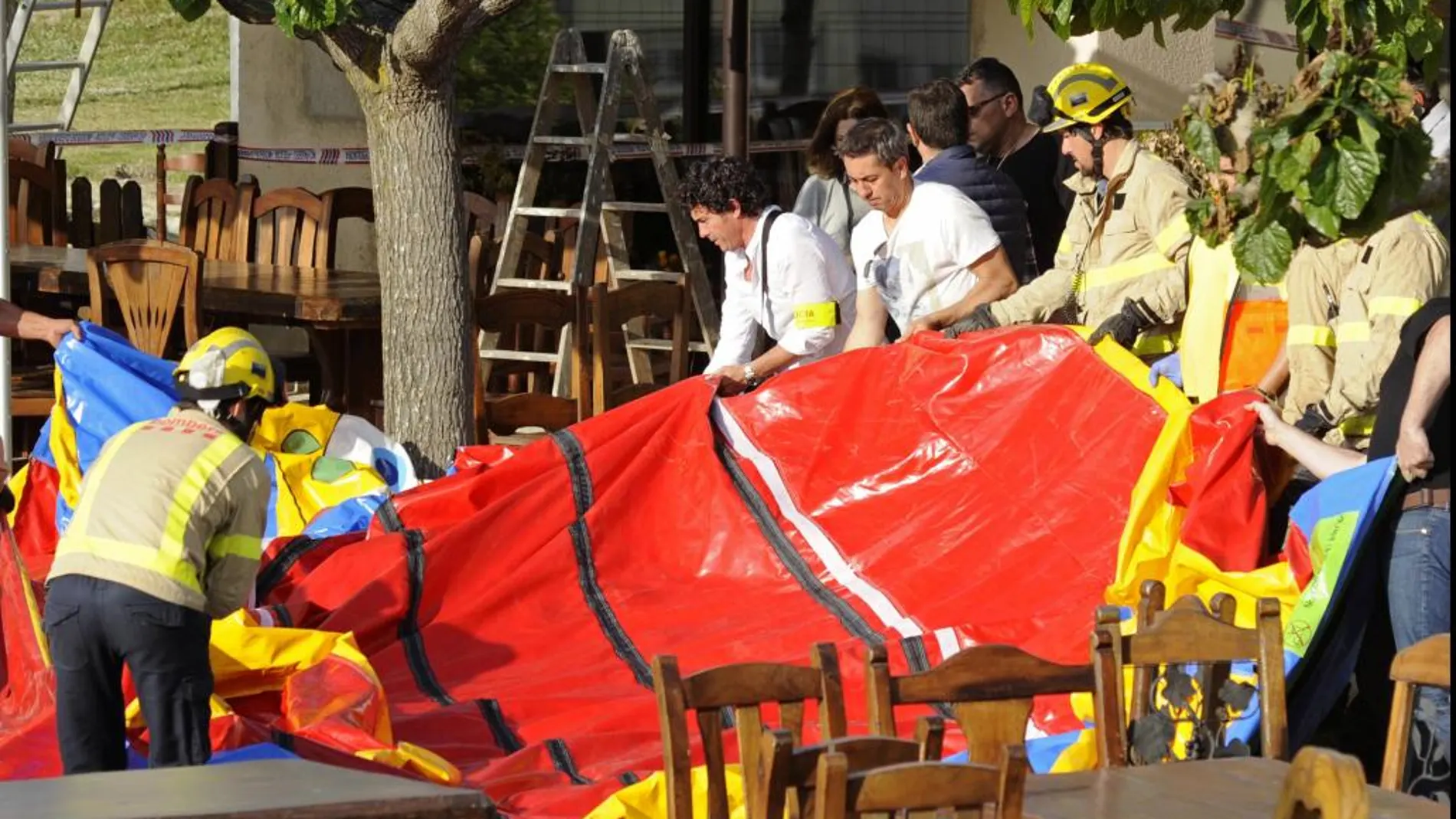 Un bombero con restos del castillo hinchable del restaurante Mas Oller, de Caldes de Malavella.