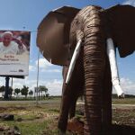 Un cartel da la bienvenida al papa Francisco junto a la escultura de un elefante en el aeropuerto internacional Jomo Kenyatta en Nairobi
