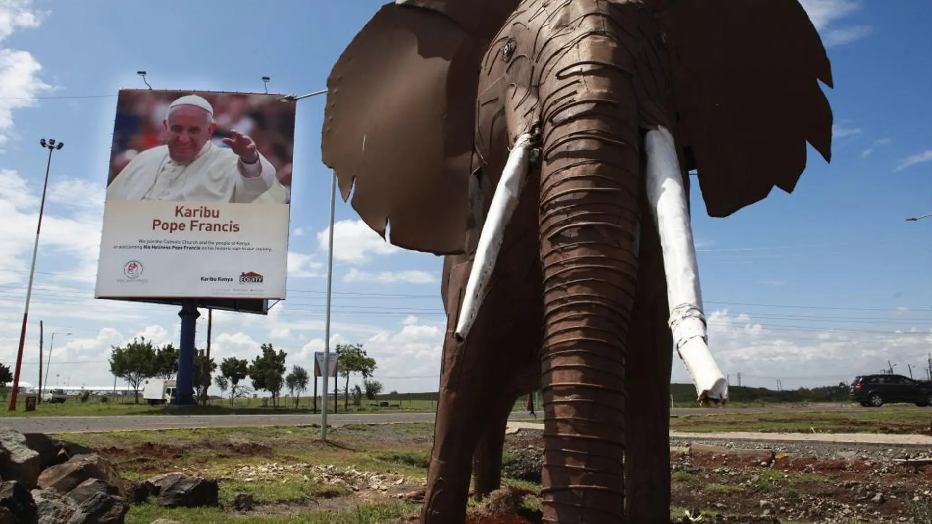 Un cartel da la bienvenida al papa Francisco junto a la escultura de un elefante en el aeropuerto internacional Jomo Kenyatta en Nairobi