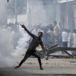 Un joven lanza piedras contra la policía india durante unas revueltas en Srinagar.