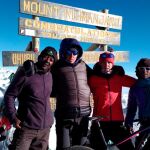Las dos deportistas en el momento de hacer cima en el Kilimanjaro junto a sus guías