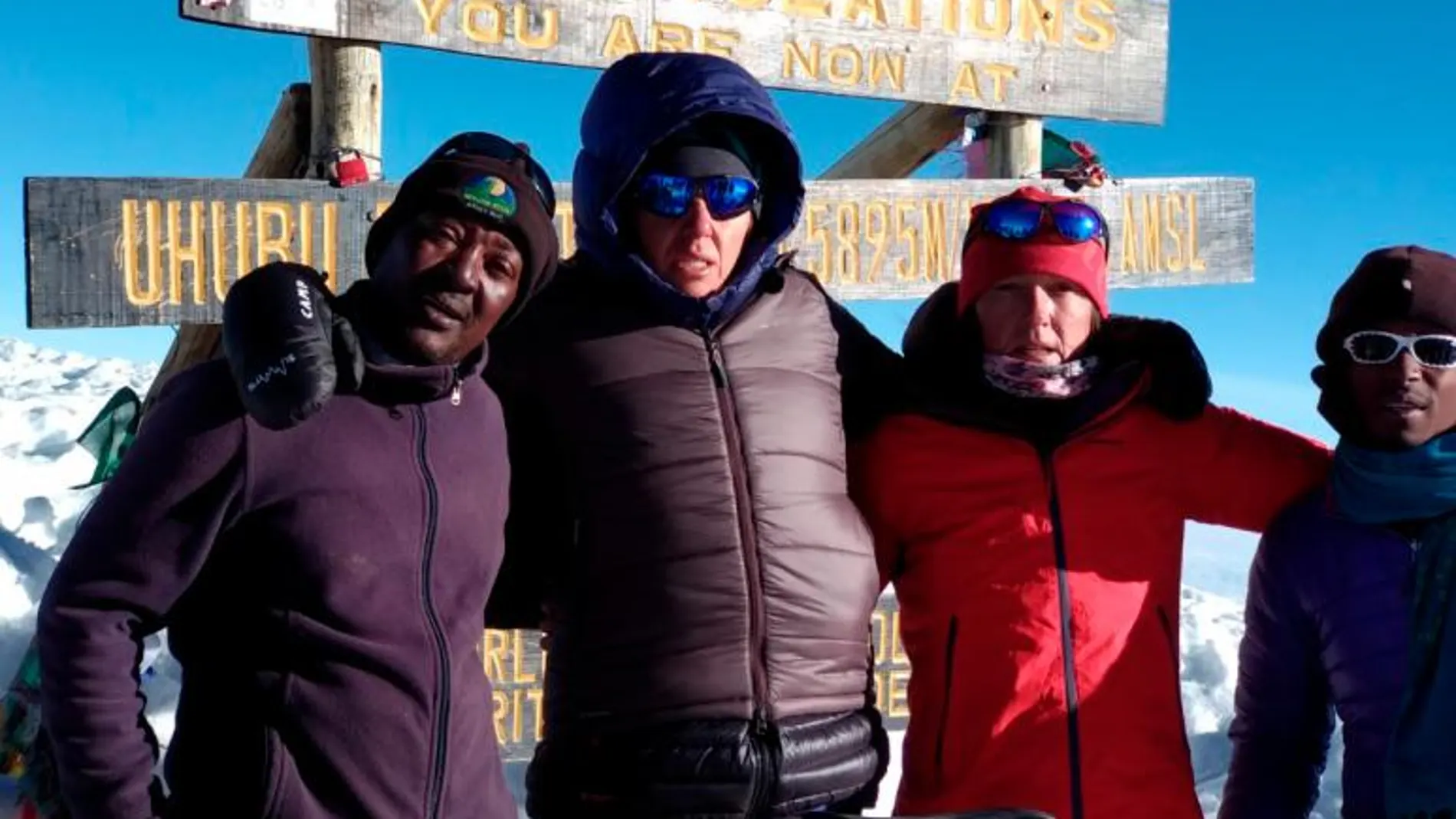 Las dos deportistas en el momento de hacer cima en el Kilimanjaro junto a sus guías