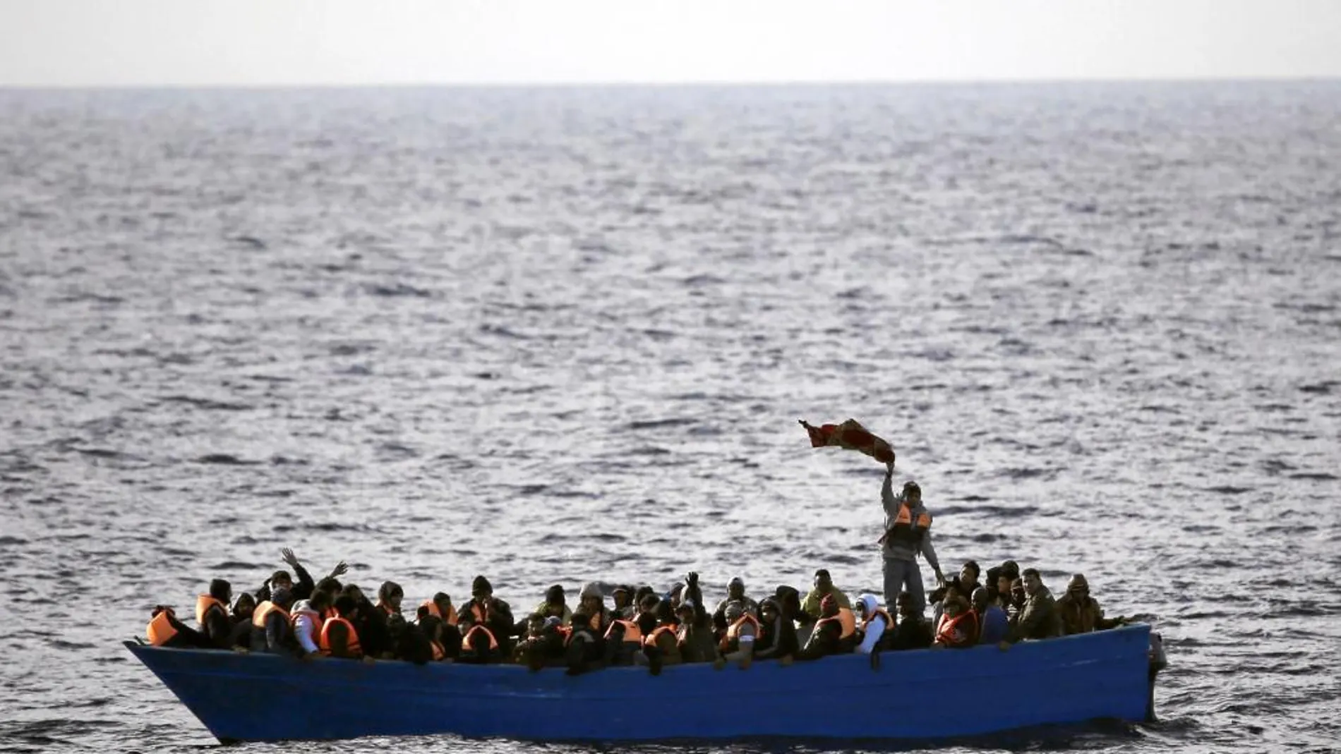 Una barca de madera llena de inmigrantes navega a la deriva en aguas libias