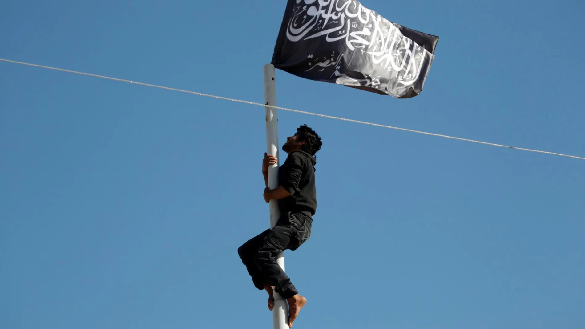 Un miembro de Al Qaeda coloca una bandera en Aritha