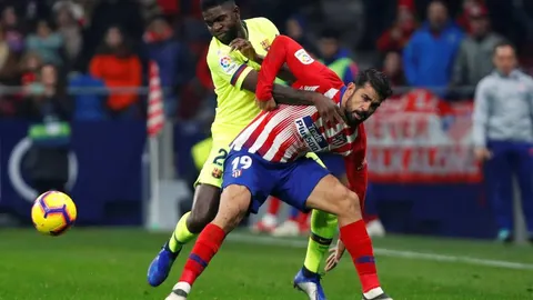 El delantero del Atlético de Madrid, Diego Costa, disputa un balón en presencia del azulgrana Samuel Umtiti / Reuters