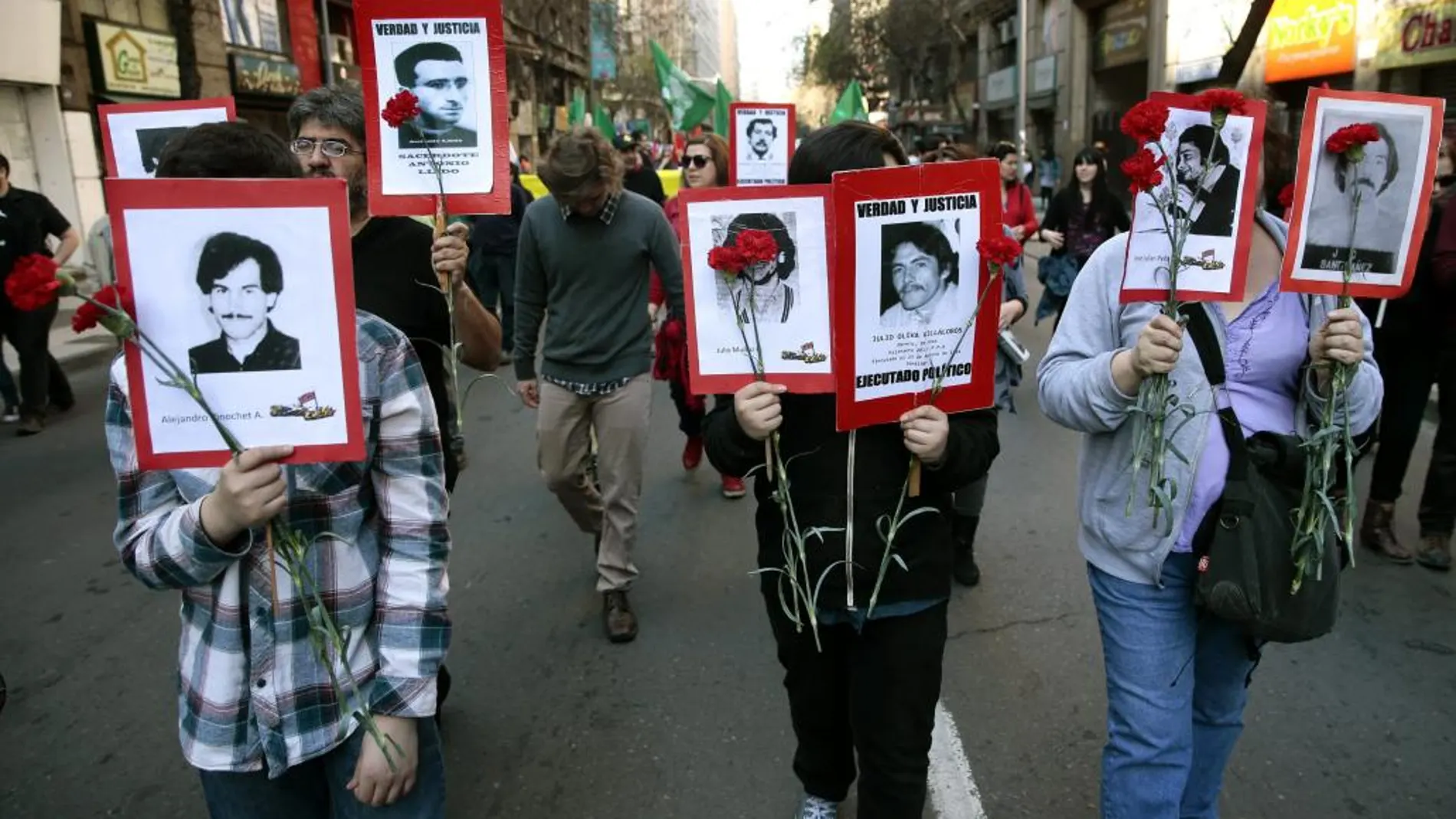 Los manifestantes portan retratos de víctimas del Golpe de Estado de 1973