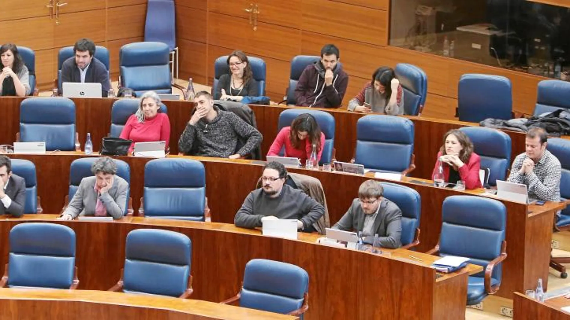 El nuevo diputado de Podemos (abajo, segundo por la izquierda) sorprendió ayer al acudir al Pleno con traje, en contraposición al estilo informal que reina en la bancada de su grupo en el que ningún parlamentario lleva corbata