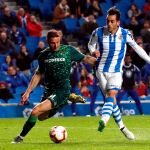 “Juanmi” de la Real Sociedad golpea el balón ante el jugador del Betis, Joaquín Sánchez / Efe