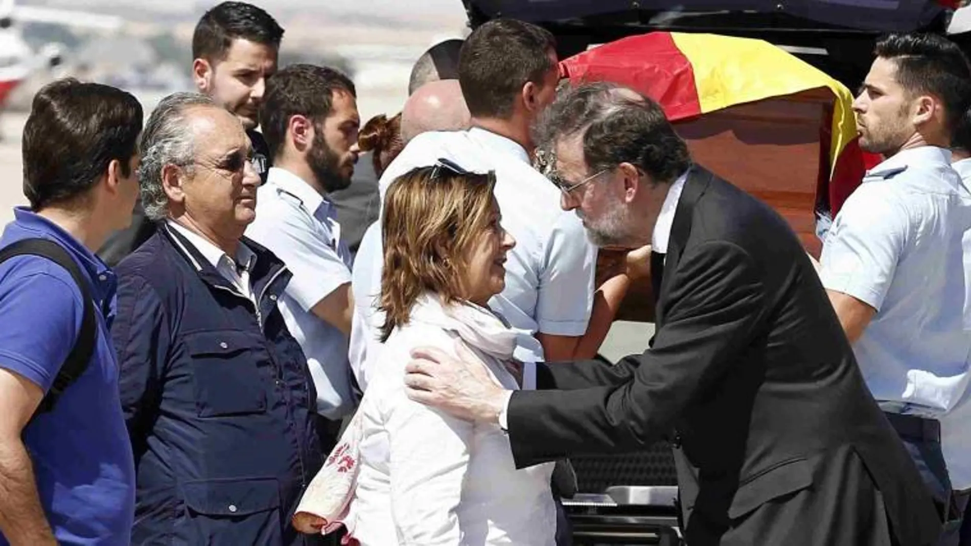 El presidente del Gobierno, Mariano Rajoy (3i), entrega a la familia de Ignacio Echeverría, la Gran Cruz del Mérito Civil que le ha sido otorgada, tras recibir el féretro del joven hoy en la base aérea de Torrejón de Ardoz.