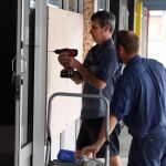 Dos hombre protegen las ventanas ante la llegada del potente ciclón en Townsville