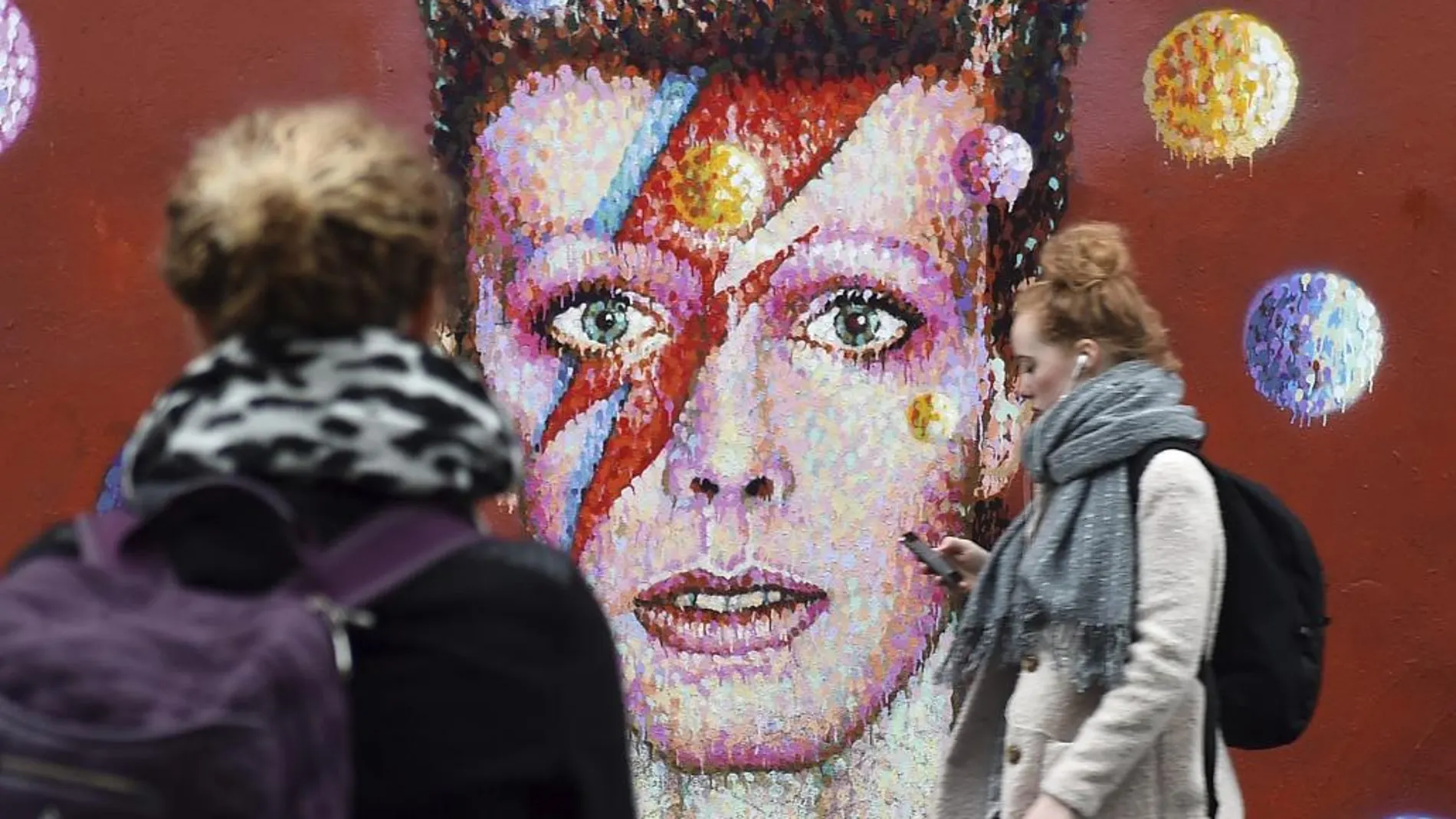Dos mujeres frente a un mural dedicado al cantante británico David Bowie en Brixton, Londres