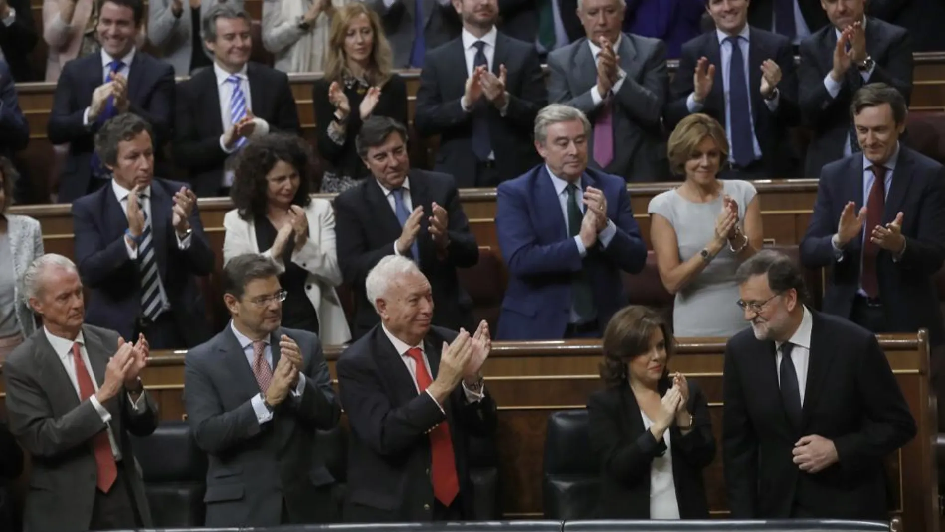 El líder del PP y presidente del Gobierno en funciones, Mariano Rajoy (d) es aplaudido por los diputados de su partido.