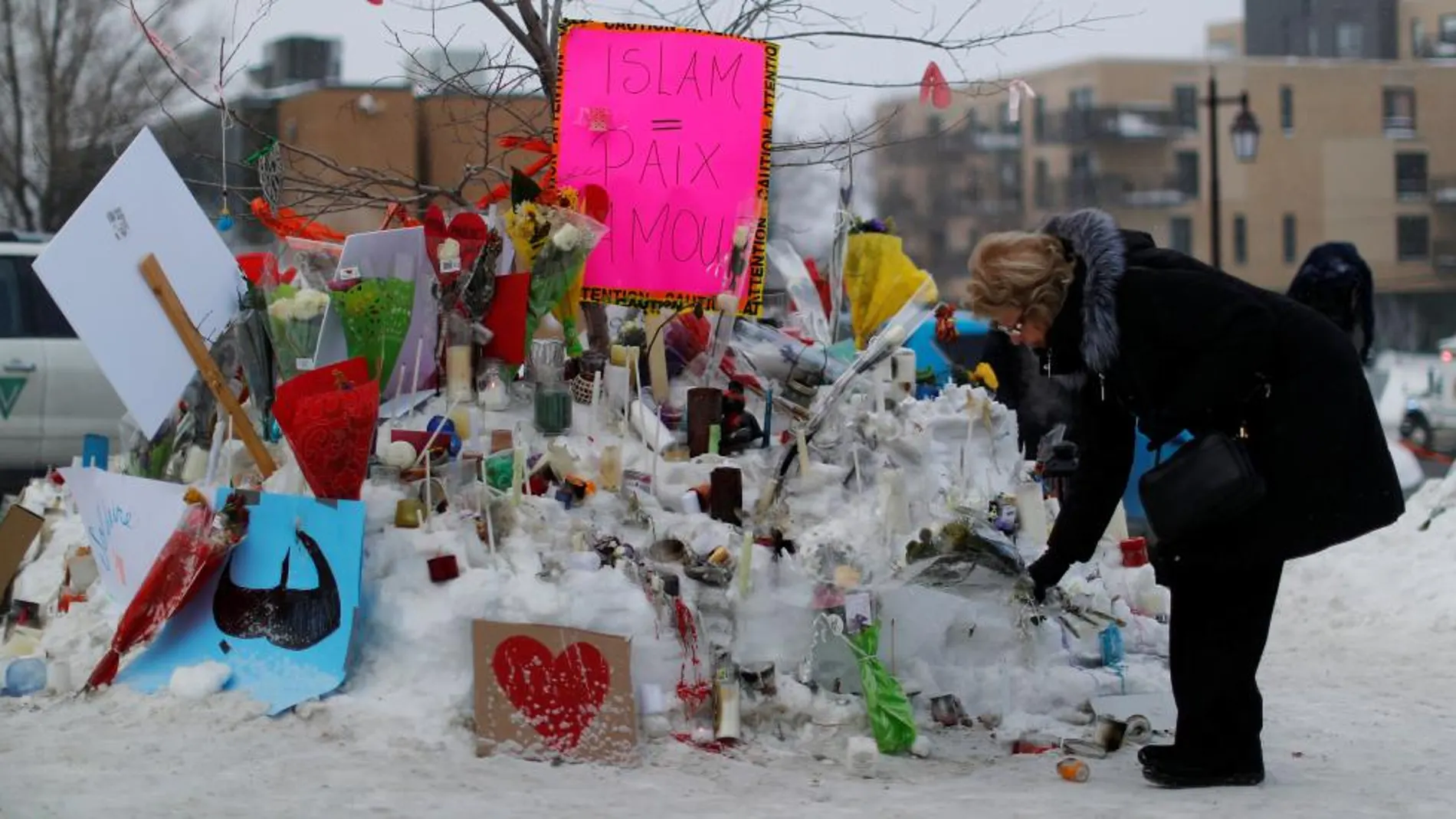 Varias personas depositan flores en una vigilia en el Parlamento e Ottawa en recuerdo de las víctimas