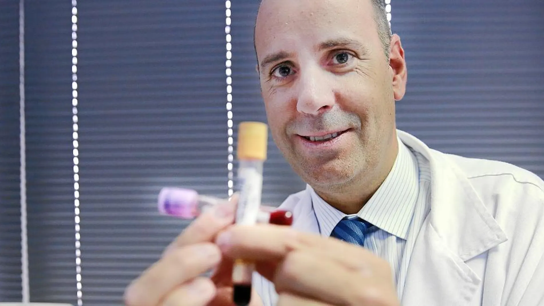 El oncólogo Javier Cortés con dos de las muestras con las que trabaja