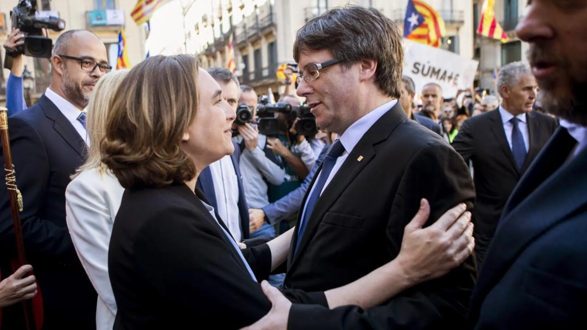 La alcaldesa de Barcelona, Ada Colau (i), saluda al presidente de la Generalitat, Carles Puigdemont (d), durante la concentración de alcaldes.